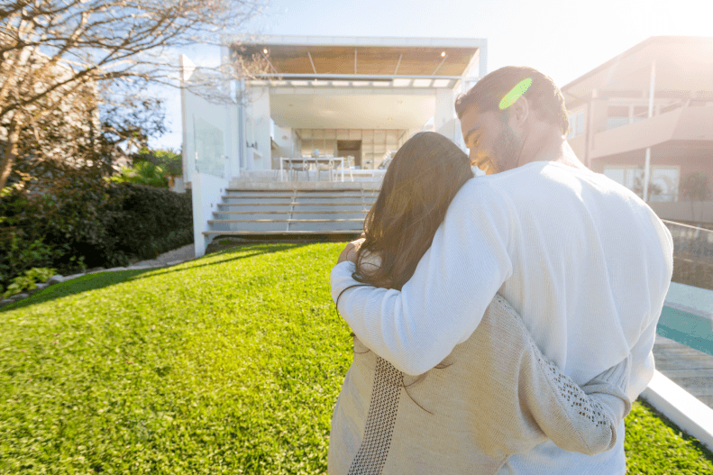 A couple standing in front of a house