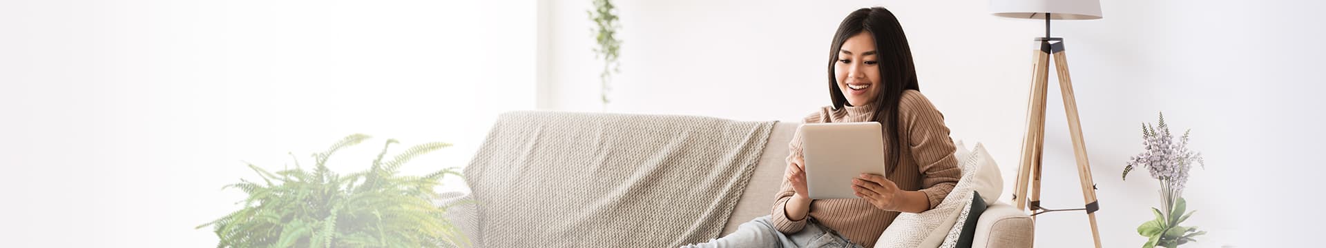 Young woman reading tablet while relaxing on sofa