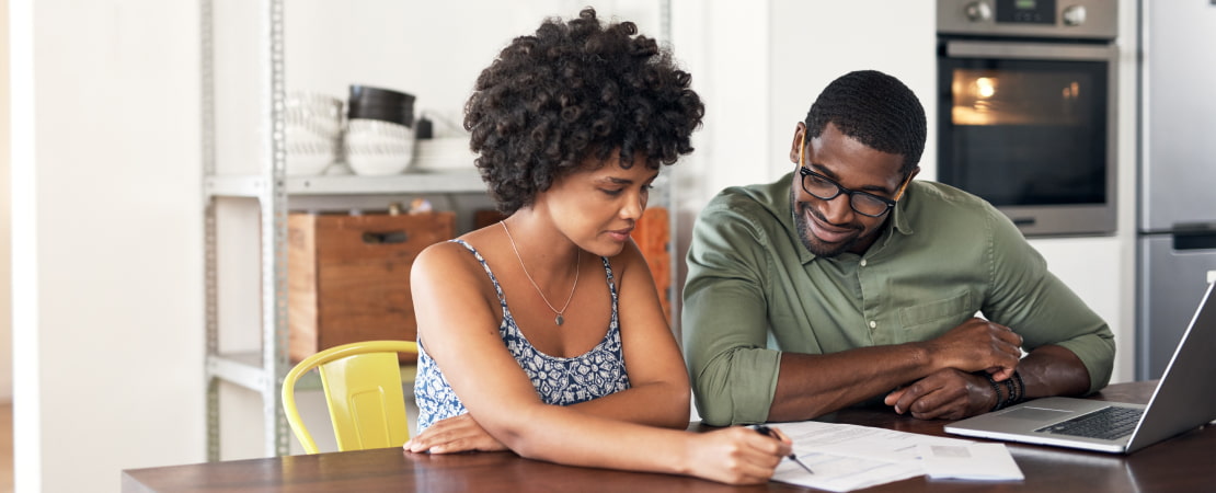 Couple looking at laptop and paperwork