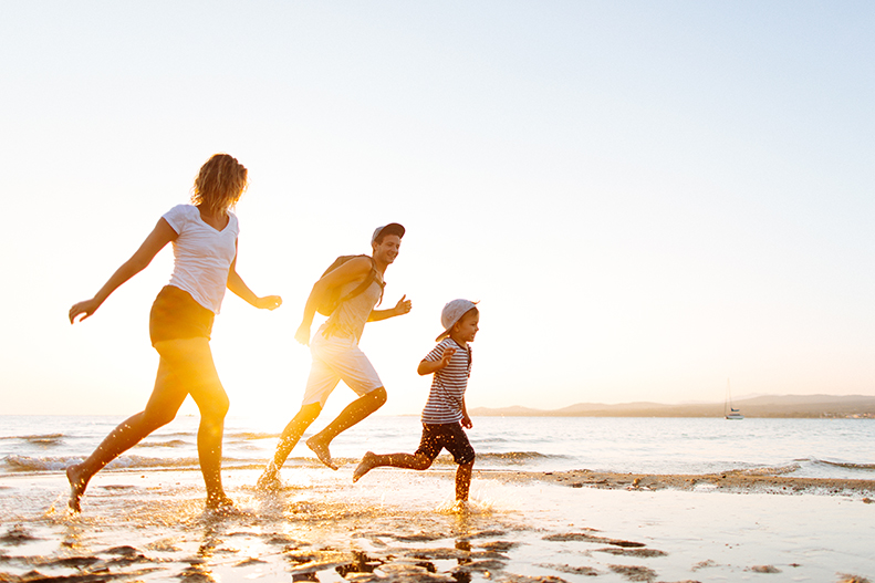 Family running in the beach