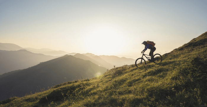man cycling down a mountain