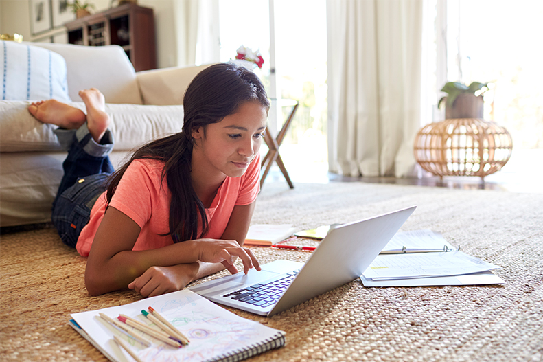 lady working on her home work in front of a laptop