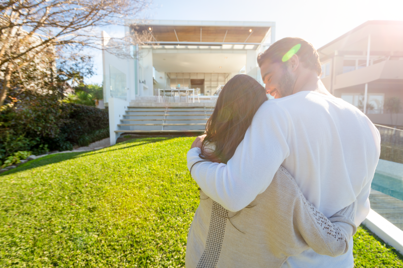 A couple standing in front of a house