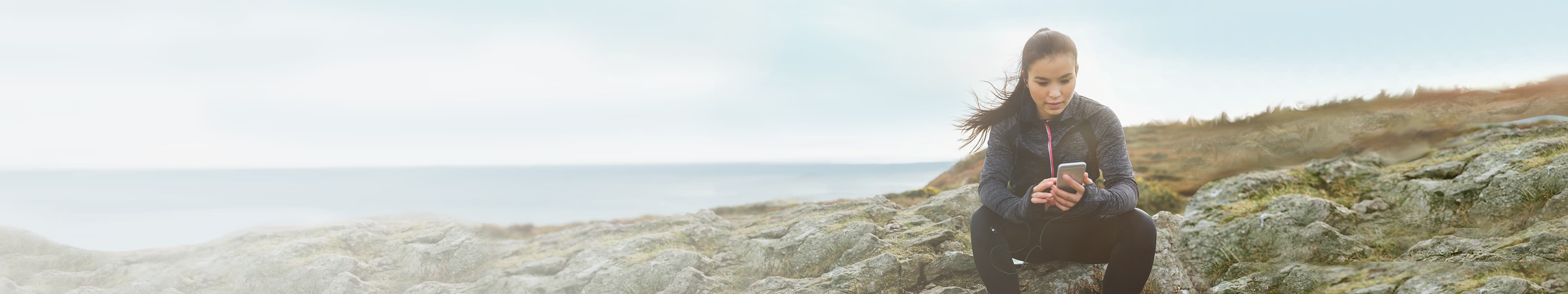 Femme consultant son téléphone intelligent à l’extérieur