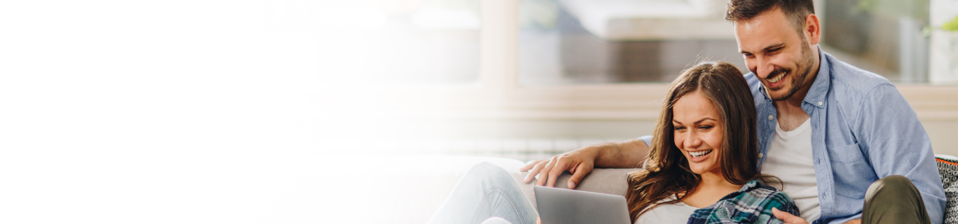 Couple smiling looking at laptop